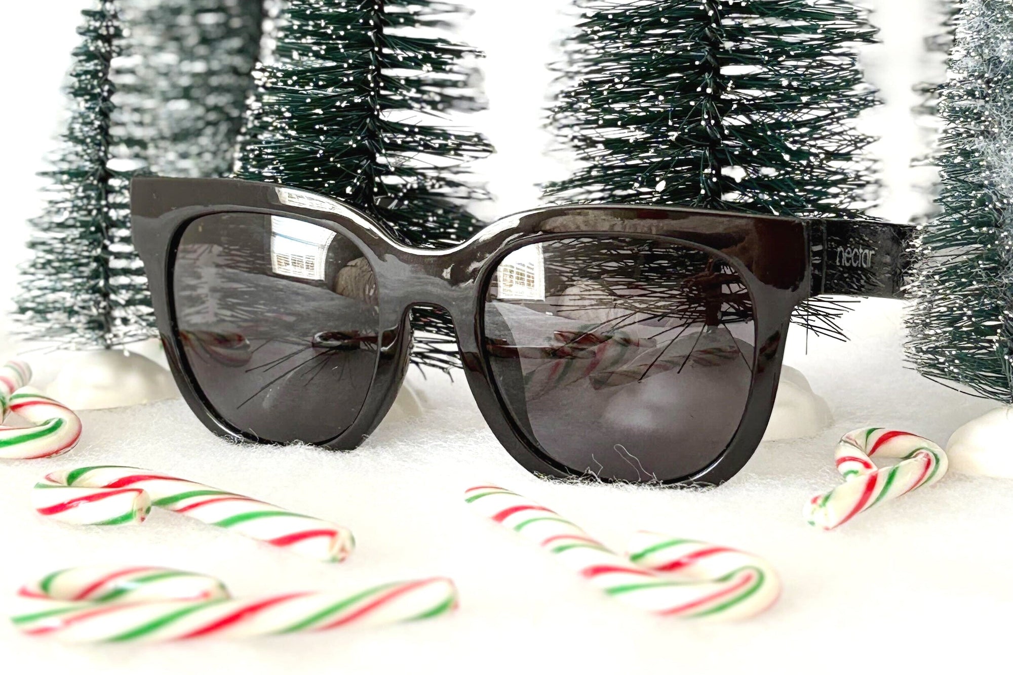 Sunglasses with Christmas trees and candy canes on a white background